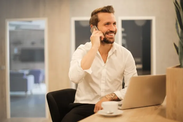 AI customer service representative assisting small business owner with phone call in bright, professional environment