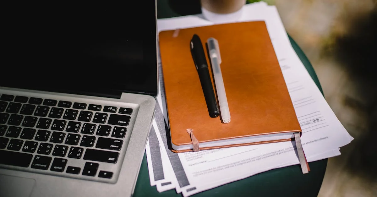 Professional workspace with leather notebook, pens, and laptop for deep studiae learning sessions
