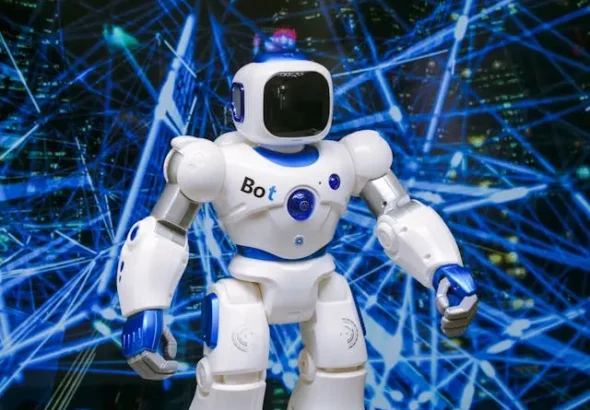 White humanoid robot with blue accents standing in front of a futuristic digital network background.