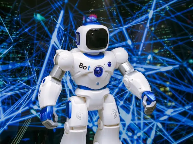 White humanoid robot with blue accents standing in front of a futuristic digital network background.